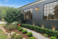 House exterior with black siding, windows, and a landscaped garden.